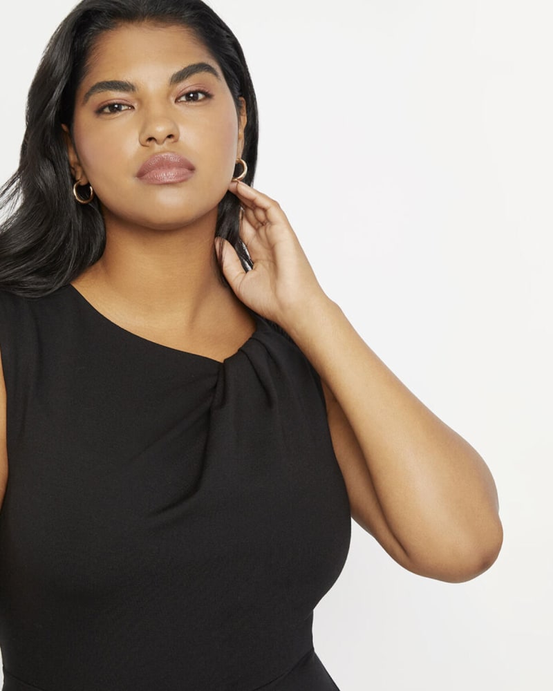 Side of a model wearing a size 28 Twisted Shoulder Sheath Dress in Black by ELOQUII. | dia_product_style_image_id:309953
